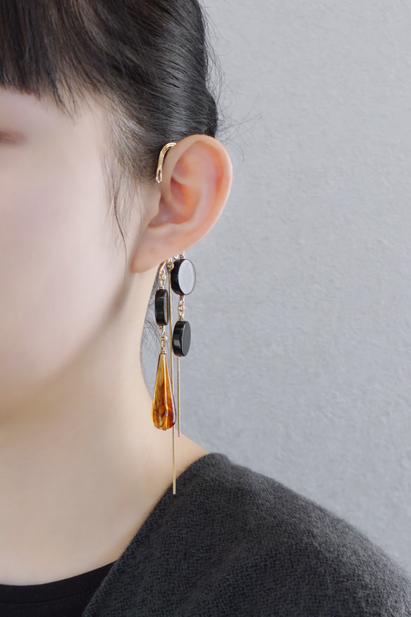 這款「點點」托特包，精緻優雅，足以媲美外套。包身飾有同色系吊墜和圓形瑪瑙耳鉤。 第3張的照片