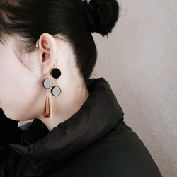 這款「點點」托特包，精緻優雅，足以媲美外套。包身飾有同色系吊墜和圓形瑪瑙耳鉤。 第5張的照片