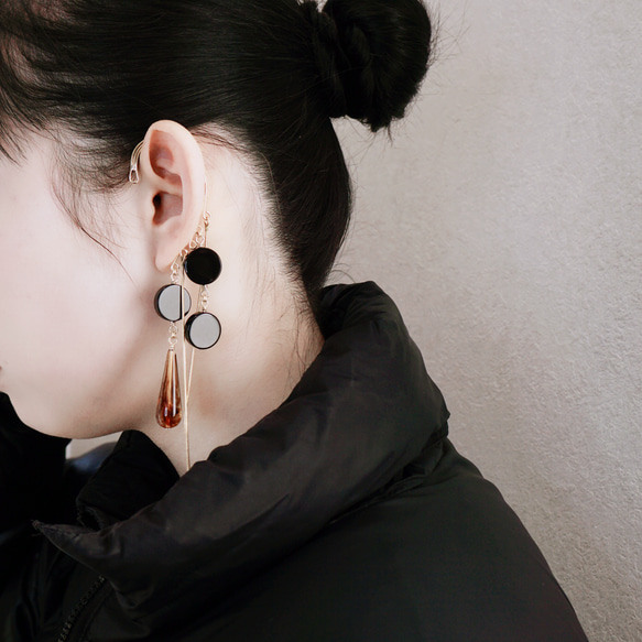 這款「點點」托特包，精緻優雅，足以媲美外套。包身飾有同色系吊墜和圓形瑪瑙耳鉤。 第5張的照片