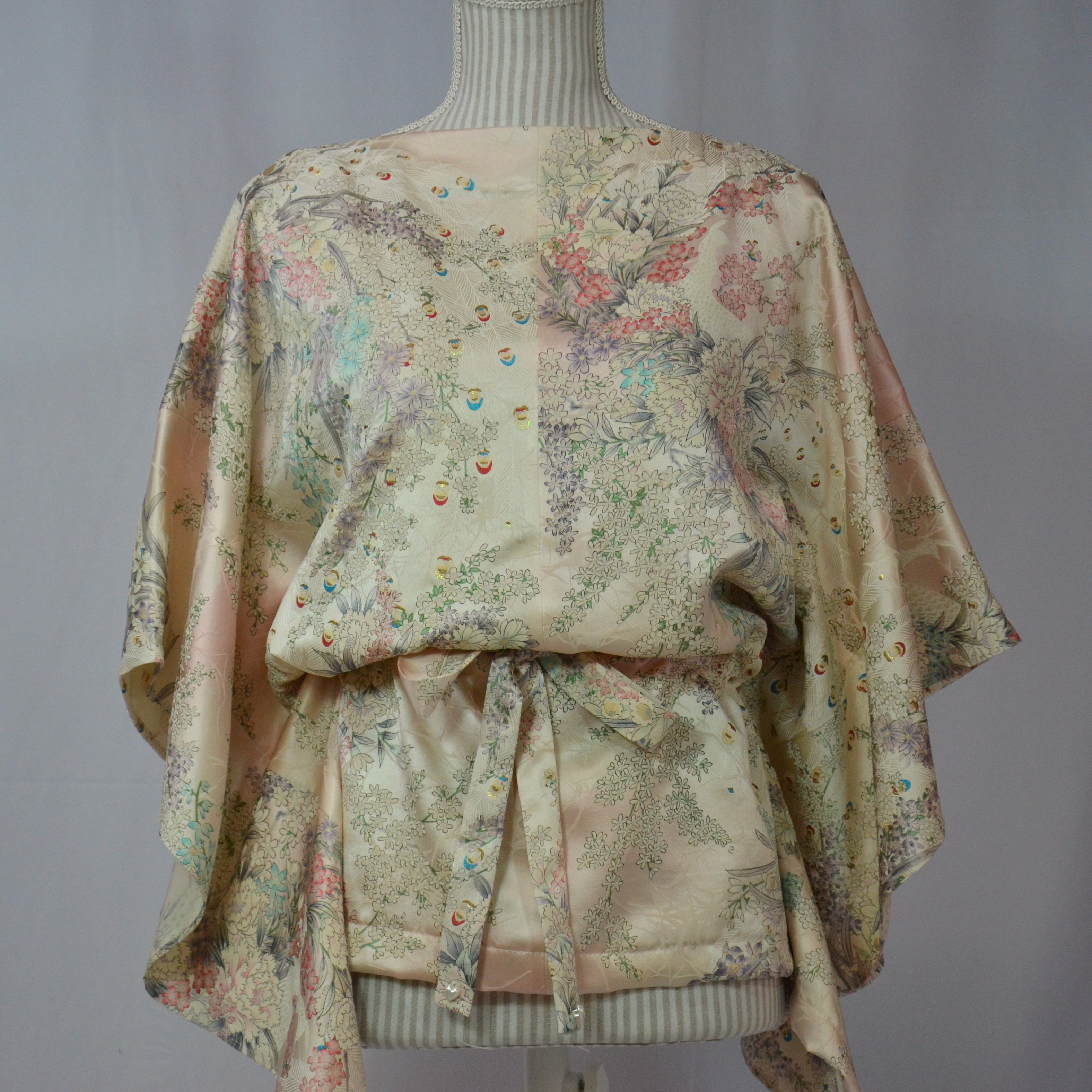 螺鈿細工を模した孔雀の羽根が煌めく仄かな薄桜色綸子のブラウス