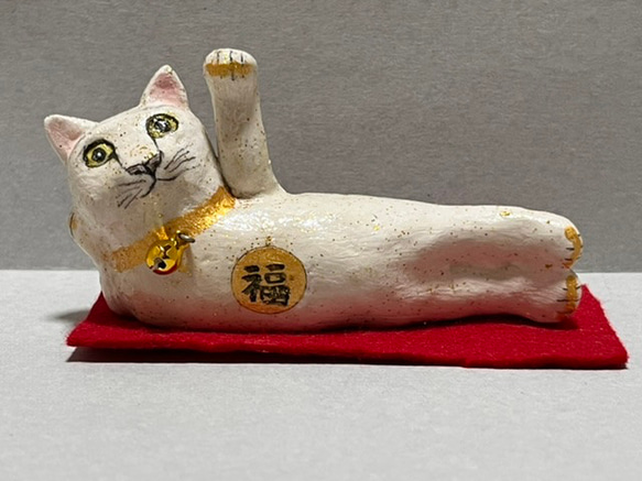 足を伸ばした白と金粉の招き猫（小）置物＃58（石粉粘土と新聞紙