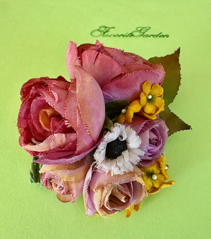 A corsage of five roses and yellow flowers