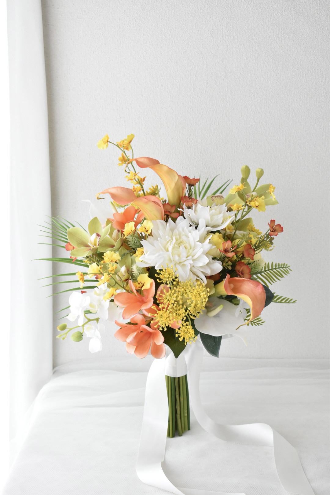 オレンジ色のプルメリアとカラーのクラッチブーケ