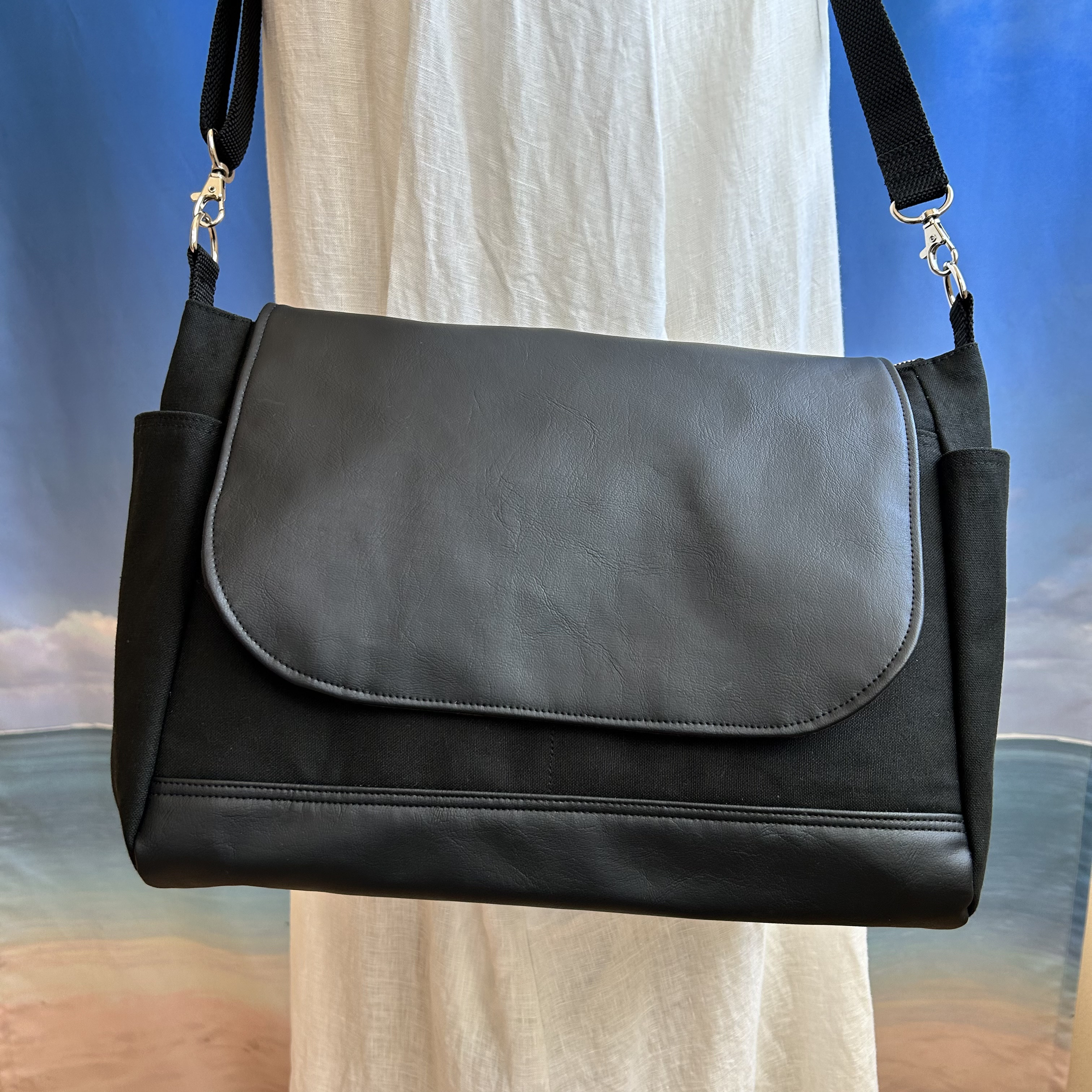 レザーフタ付きの　ポケット8室　サイドポケットが便利な　ショルダーバック　帆布黒色　合皮レザー　色変更可能