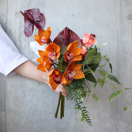 テラコッタやワインレッドのシックな海外花を細かく束ねた大人