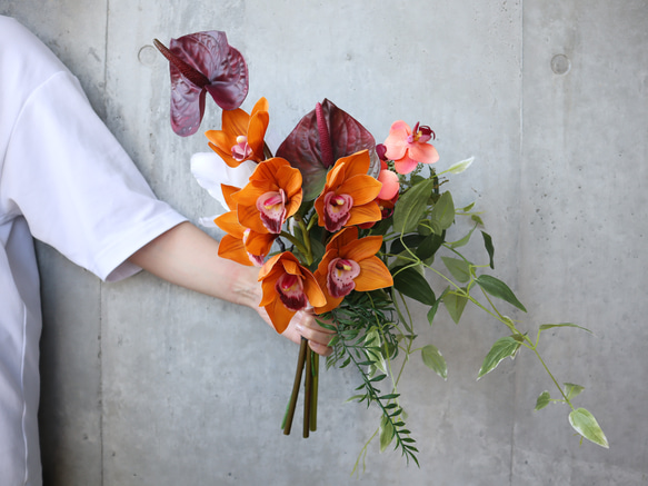 テラコッタやワインレッドのシックな海外花を細かく束ねた大人