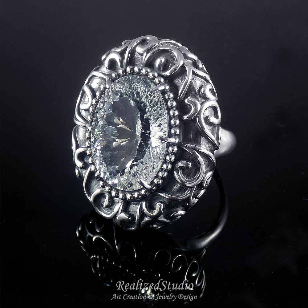 ノクターン | スパイラル模様とレリーフを施したクラシカルな卵型大ぶりリング - ピュアホワイトトパーズ。