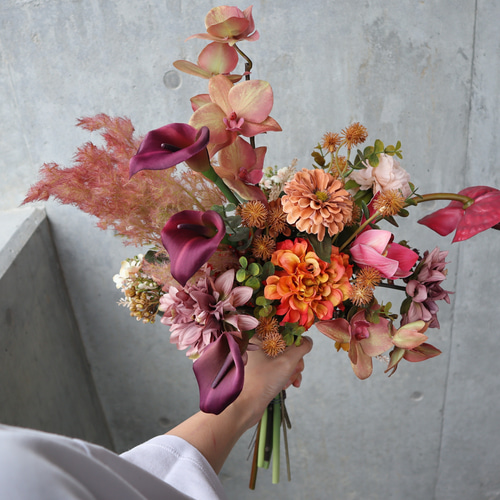 大人ピンクとテラコッタの胡蝶蘭やアンスリウムを束ねた品のあるブーケ