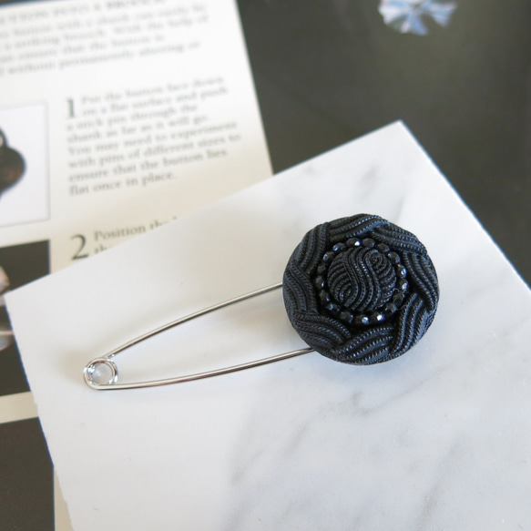 レトロなブラックボタンのストールピン　ボタンブローチ　かぶとピン　 1枚目の画像