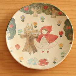 一個小的紅色騎馬兜帽蛋糕盤與a粉的狼。 第1張的照片