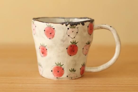 一個杯子紅色和桃紅色草莓用碾碎的手。 第1張的照片