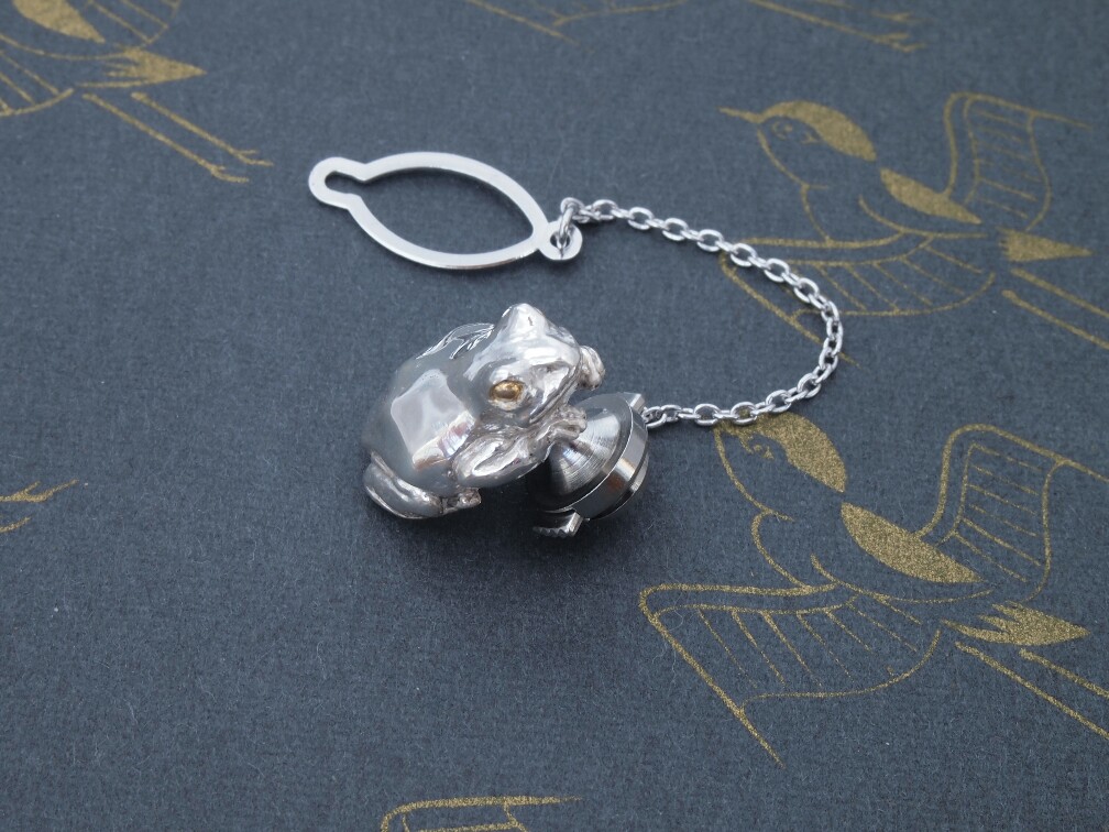 金の眼の、銀蛙ピンバッジ