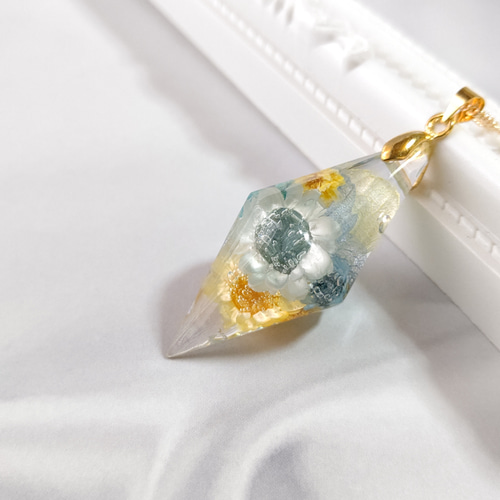 水色と黄色のドライフラワーを詰め込んだひし形のクリスタル型レジンの