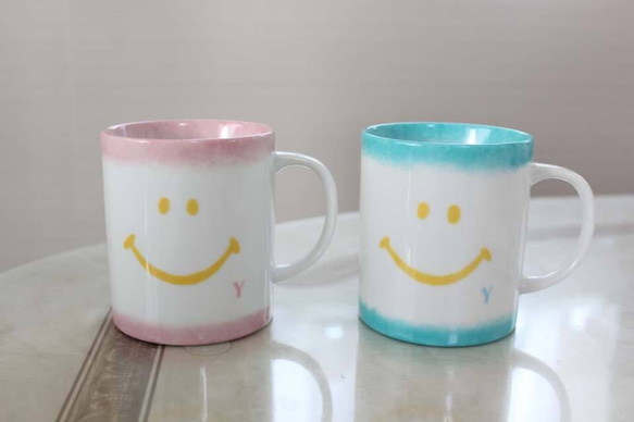 【ペア】ピンクとエメラルドグリーンのニコちゃんマグカップ 2枚目の画像