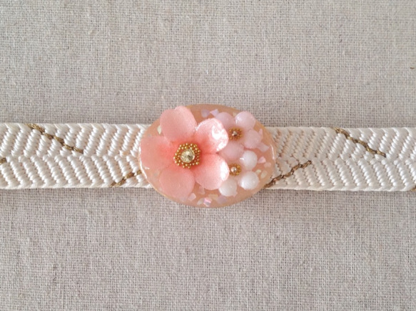 染め花を樹脂加工した桜と小花の帯留め(楕円・ピンク) 1枚目の画像