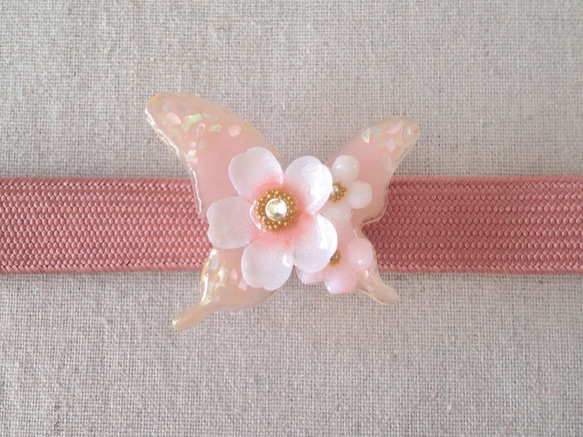 染め花を樹脂加工した桜と小花の帯留め(蝶・白とピンク) 1枚目の画像