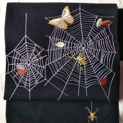 未使用 正絹 名古屋帯 蜘蛛の巣に蝶々柄 小紋紬等に 今日のトルソーさん は横段に蝶々が描かれた単衣小紋に幾何学