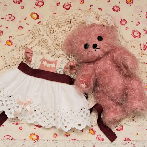 ビンテージファブリックのドレスを着たピンクのテディベア