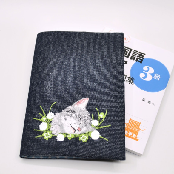 クローバーとグレーねこ刺繍A5サイズブックカバー（横書き左開き用）〈デニム〉 1枚目の画像