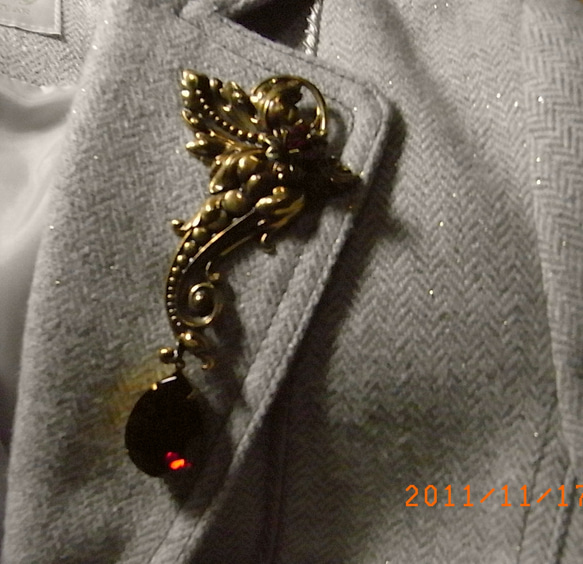 ジャケットの襟に映えるの大きなブローチ 1枚目の画像