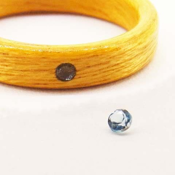 ブルートパーズ(11月の誕生石)を入れた木の指輪 【受注生産】イエローハート 独自の技法で宝石をしっかりと固定します 1枚目の画像