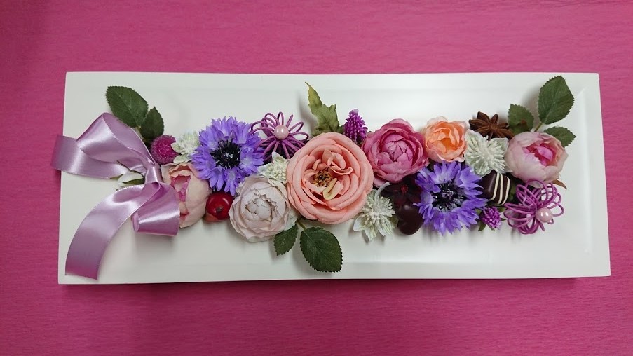 square garden（長方形のフレームの中にバラや矢車草などのお花、リンゴやチョコレート等を詰込んだアレンジ）