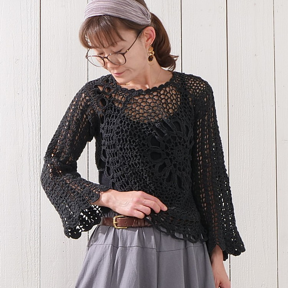 溫暖的手工針織上衣，寬鬆的針織感，花卉圖案，喇叭袖，棉質布料，黑色。 第1張的照片