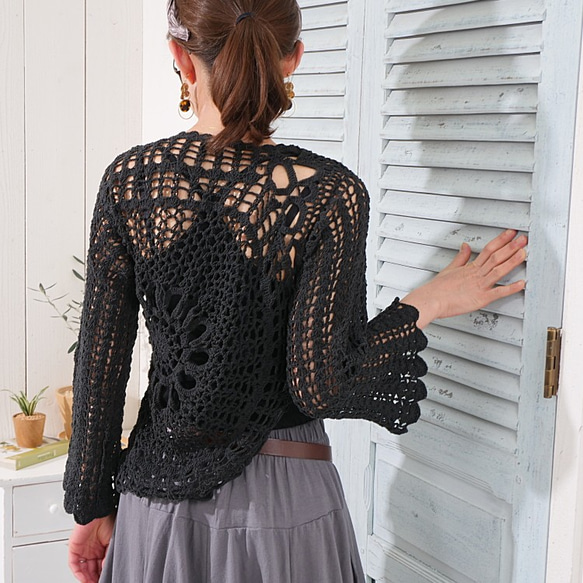 溫暖的手工針織上衣，寬鬆的針織感，花卉圖案，喇叭袖，棉質布料，黑色。 第5張的照片