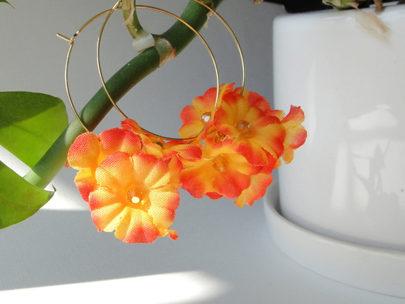 オレンジ色のお花のフープピアスです 1枚目の画像
