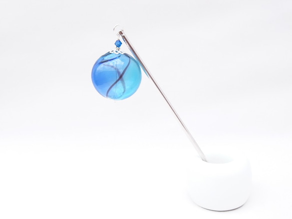 [翻譯] 一個超大的淺藍色吹製玻璃珠球，就像夏日節日里的悠悠球 第2張的照片