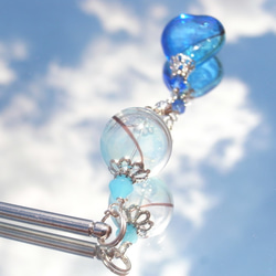 一個淡藍色的灑玻璃珠，像夏日的悠悠球一樣吹著淡藍色 第4張的照片