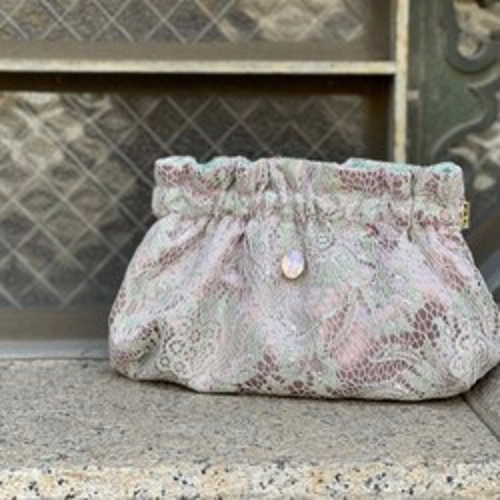 若草色のレースとくすみピンクのサテンを組み合わせた生地で作っ