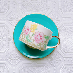 一個茶杯，上面有絢麗的花朵和蝴蝶 第1張的照片