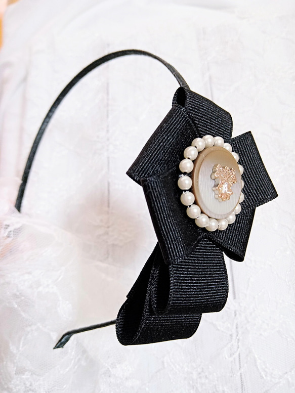 黒のグログランリボンとエンブレムボタンのカチューシャ