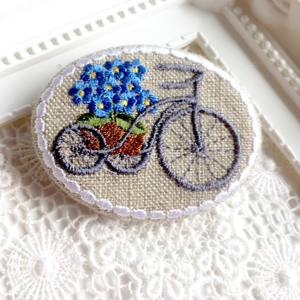 リネン　刺繡ブローチ　楕円横型　自転車に花かご　忘れな草 1枚目の画像