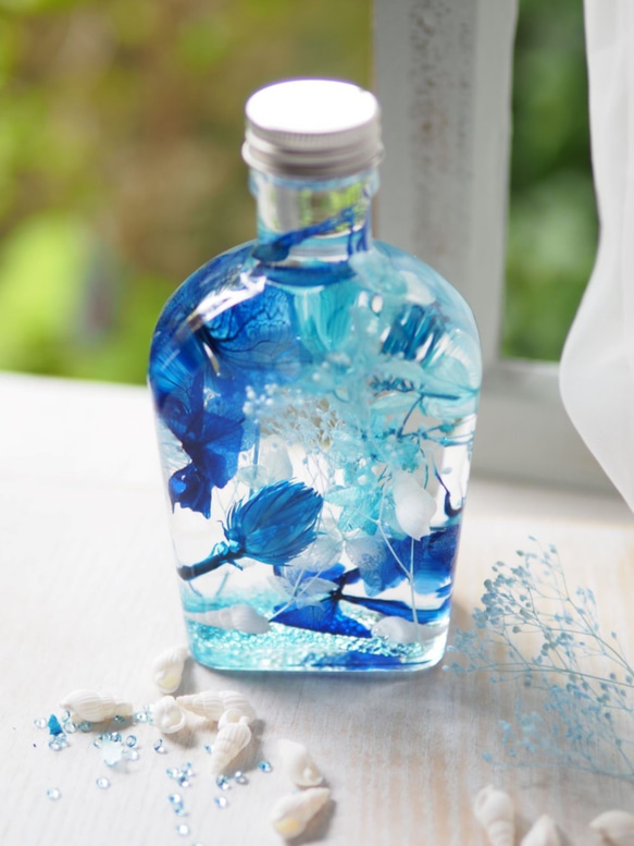 インテリアにもさわやかな　海、空、星をイメージした青いハーバリウム　プリザーブドドライフラワーを使ったウィスキー瓶タイプ 1枚目の画像
