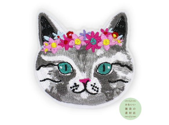 花飾りをつけたエメラルドグリーンの目のグレー猫の顔のワッペン（アイロン接着/アップリケ/刺繍/ネコ）#AP-0001 1枚目の画像