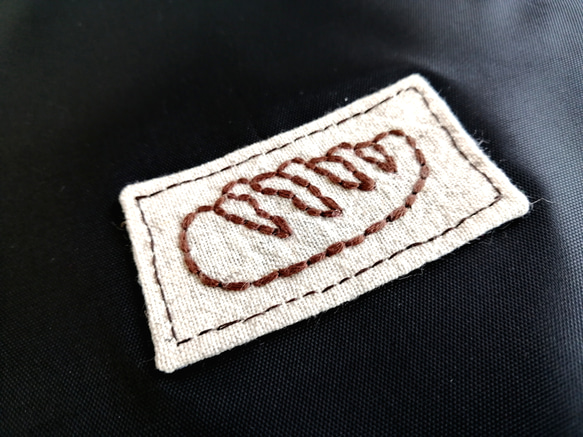 茶パンのワッペン　巾着バッグ　ウォータープルーフ　黒　手縫いの刺繍 2枚目の画像