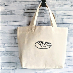 【シンプルな手縫いの刺繍】黒いパン　ミニトートバッグ　生成り　帆布　コットン　ランチバッグ　手提げ　Sサイズ 1枚目の画像