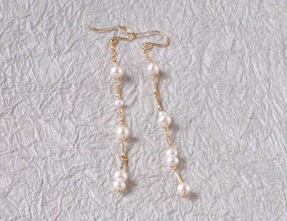 白色珍珠和線形長耳環 第5張的照片