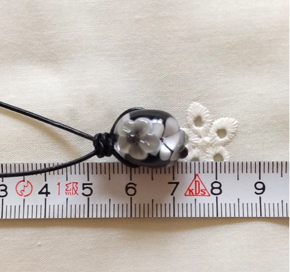 黒の花のとんぼ玉(水中花入り、まるい花びら)のネックレス(革ひも) 4枚目の画像