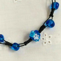 カプリブルーの花のとんぼ玉とガラスビーズのネックレス(革ひも黒  ブレスレット兼用) 1枚目の画像