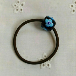 4枚の丸い花びらの花のとんぼ玉のヘアゴム(黒に青と水色とコバルトブルー) 1枚目の画像