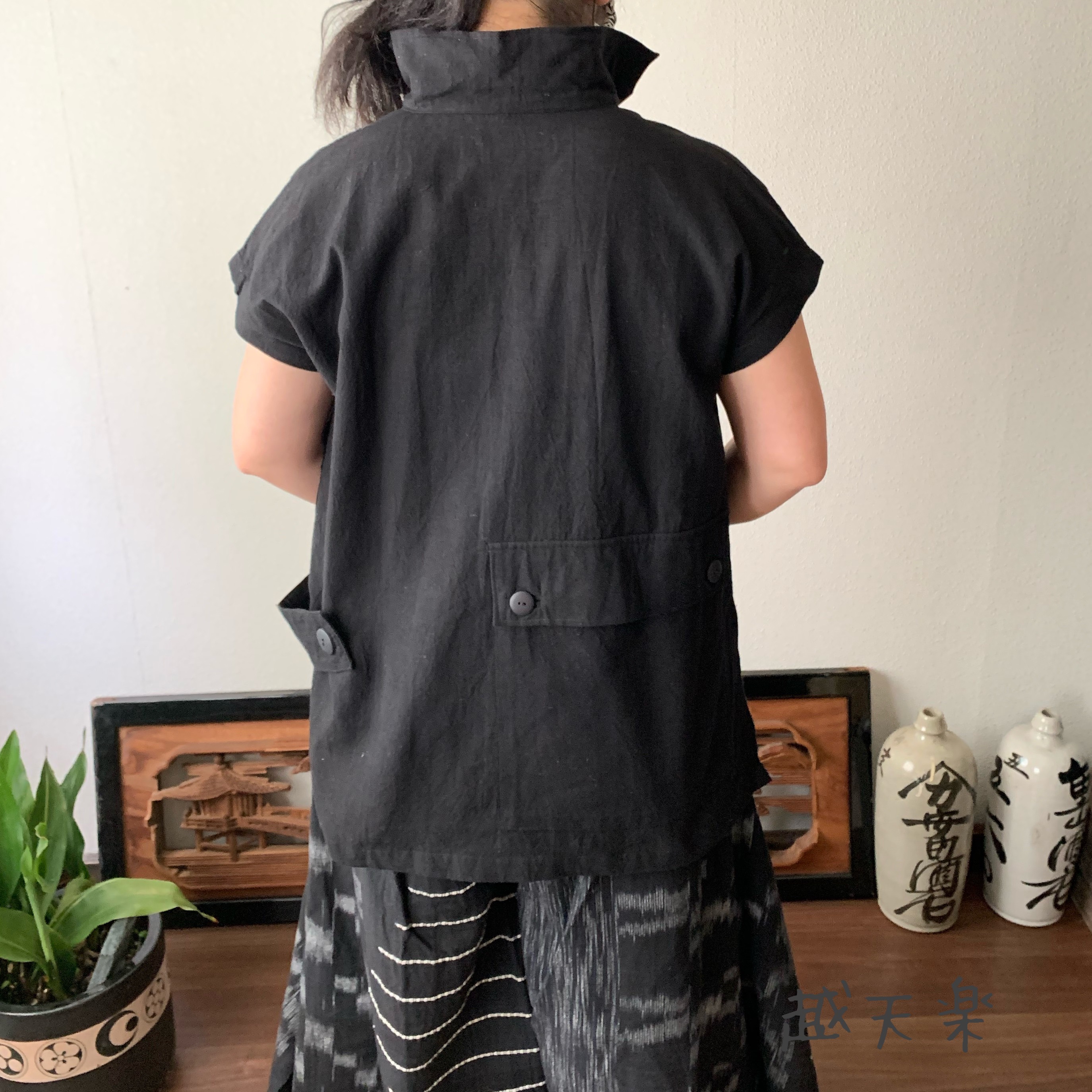 バックテールですっきりみせるハイカラー手織り綿ベストブラウス　後ろ裾のポケットとサイドベルトもアクセントに　黒無地