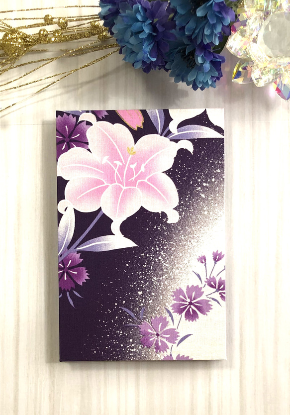 御朱印帳　黒和紙　大判18㎝×12㎝　蛇腹タイプ　両面美しいゆりの花が描かれ紫地にとても映え素敵なデザインです。 2枚目の画像
