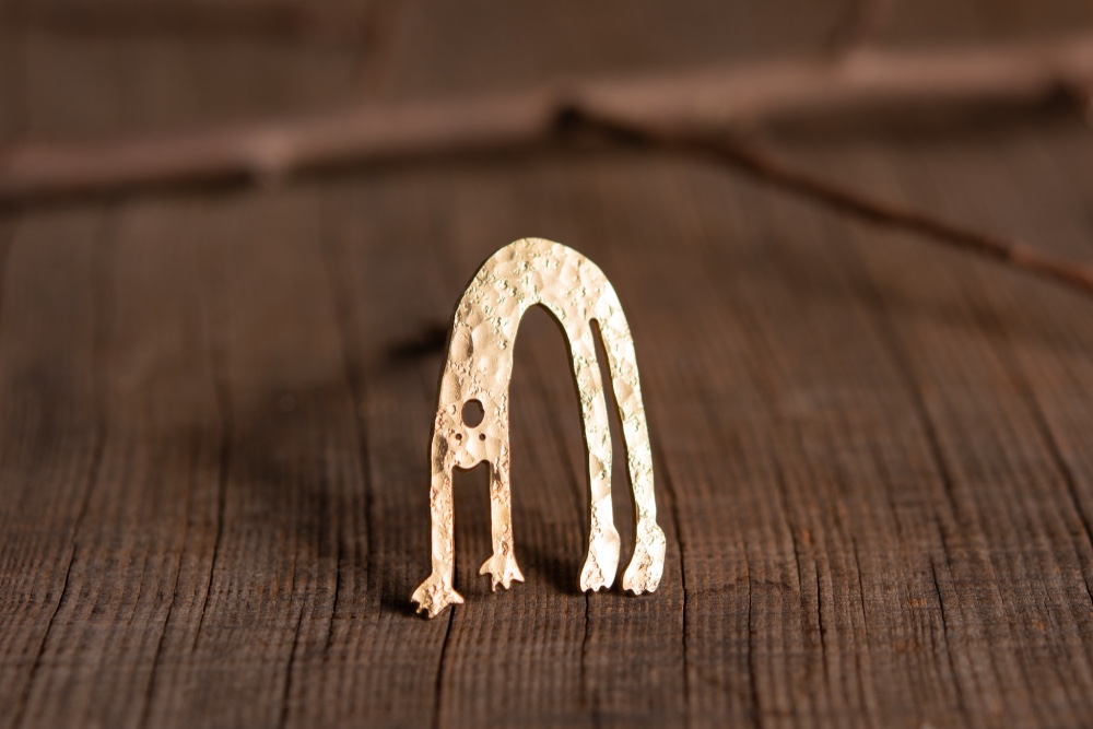 ブリッジをしている人のブローチ